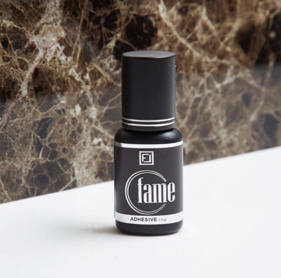 Fame Glue flawless mit Marmor Hintergrund ,bester schnelltrocknender Wimpernkleber mit niedriger Luftfeuchtigkeit für Wimpernverlängerung. schneller lashkleber für fortgeschrittene.